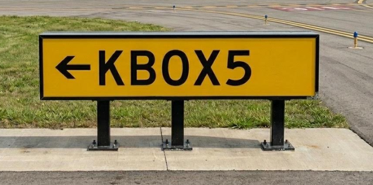 Yellow KBOX5 taxiway-style directional sign